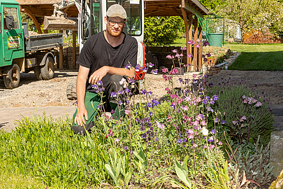 Elmanuel Breitzke vor einem Beet mit Nutzpflanzen