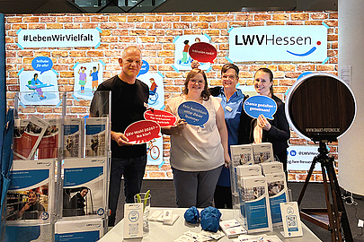 Mit Sprechblasen kreativ werden: Gestalten Sie Ihr Bild zum Thema Inklusion Vier Personen halten Sprechblasen mit Schlagworten zum Thema Inklusion vor der Fotobox