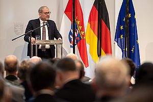 Prof. Dr. Emile Schrijver am Rednerpult vor vollbesetzten Stuhlreihen. Er hält die Gedenkrede.