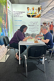 Eine Frau und ein Mann am Tisch beim Fingeralphabete