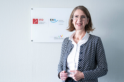 Susanne Tölzel vor einem Schild der EAA Wiesbaden