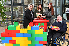 Lego Steine werden in eine Sammeltonne geworfen.