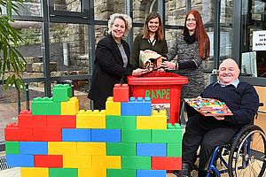 Lego Steine werden in eine Sammeltonne geworfen.