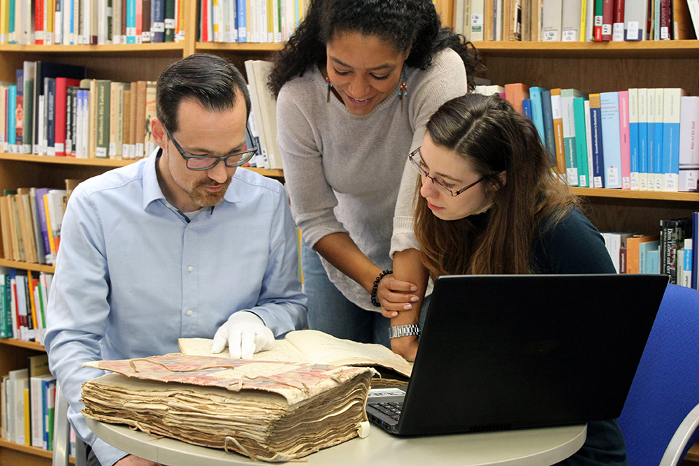 Drei Personen bei der Recherche im Archivinformationssystem Arcinsys des Landes Hessen 