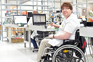 Eine Person im Rollstuhl an seinem Arbeitsplatz (Foto: Fotolia)